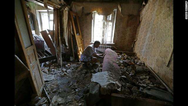 Местный житель Александр Авдюхин осматривает свою квартиру после обстрела в Донецка, 14 августа 2014 года.