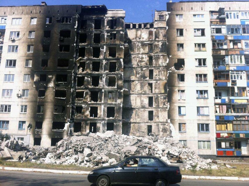 Груда щебня в передней части многоэтажного здания в жилом районе города Лисичанска после попадания ракеты во время боевых действий между украинской армией и пророссийскими повстанцами, 16 августа 2014 года. 