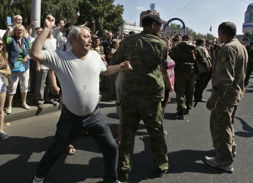 Мужчина бросает яйцо в пленого украинского солдата на центральной площади Донецка 24 августа 2014 года. 
