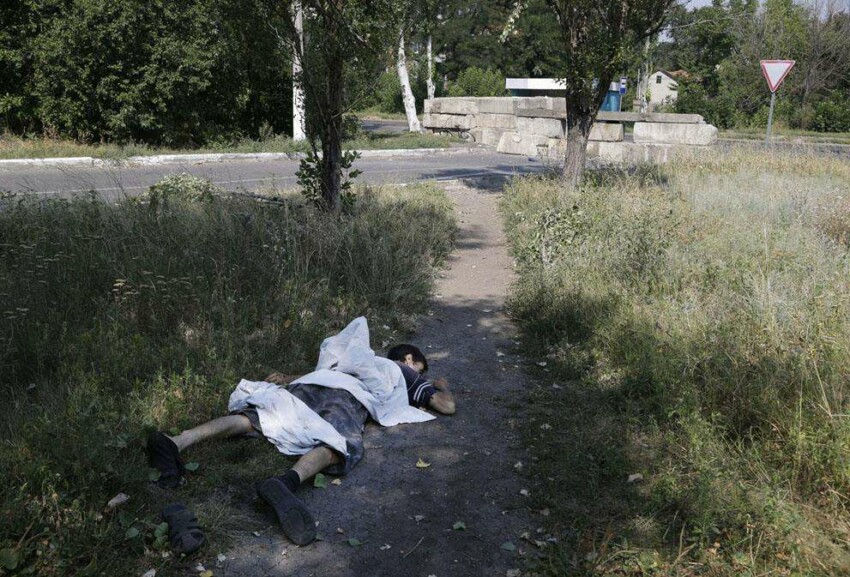 Мертвое тело лежит на одной из улиц Петровского района Донецка 13 августа 2014 года.