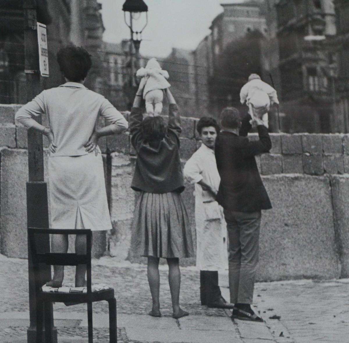 Пара из Западного Берлина показывают внуков бабушке и дедушке, живущим в Восточном Берлине