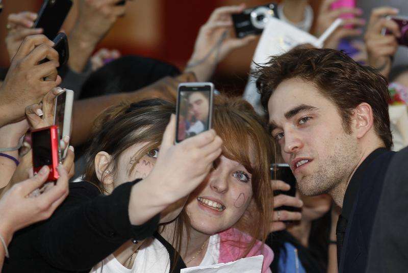 Actor Robert Pattinson poses with fans at the premiere of Water for Elephants at the Westfield in London