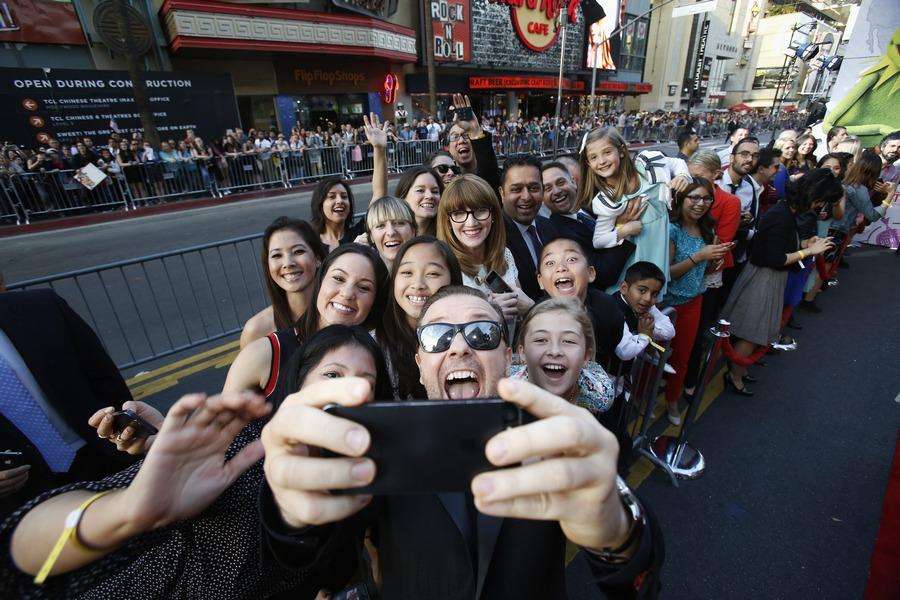 Cast member Gervais takes a "selfie" with some fans at the premiere of "Muppets Most Wanted" at El Capitan theatre in Hollywood