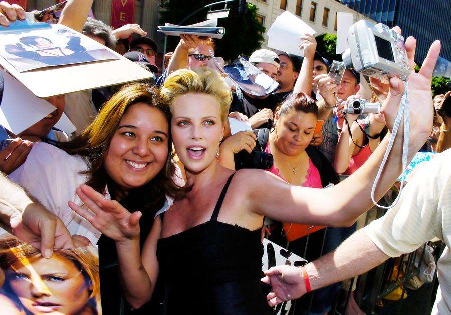 Actress Theron poses with fan after receiving star on Hollywood Walk of Fame in Los Angeles