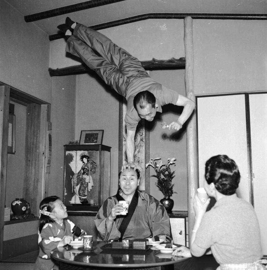 Японский акробат Gyokusho Terajima прерывает семейный ужин, чтобы выполнить экспромтом сальто над головой брата