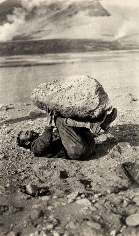 Человек ногами поднимает кусок гигантской пемзы в сентябре 1921 года.