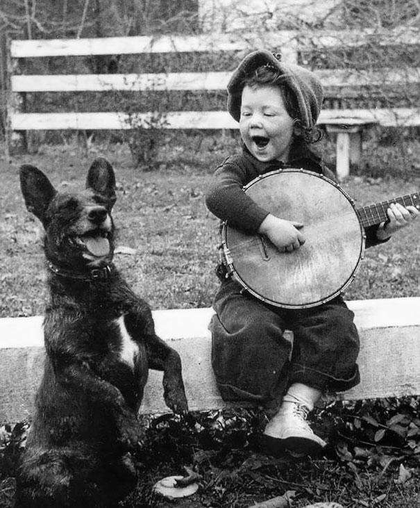 Девушка, играющая на банджо своей собаке