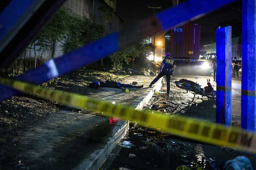 TOPSHOT - EDITORS NOTE: Graphic content / Philippine Scene of the Crime Operatives (SOCO) work at the scene where two suspects were shot dead following an encouter and shootout with police at a checkpoint along a highway in Manila on August 28, 2016. More than 2,000 people have died violent deaths since Duterte took office two months ago and immediately implemented his scorched-earth plans to eradicate drugs in society, ordering police to shoot dead traffickers and urging ordinary citizens to kill addicts. The bloodbath has seen unknown assailants kill more than half the victims, according to police statistics, raising fears that security forces and hired assassins are roaming through communities and shooting dead anyone suspected of being involved in drugs. / AFP / NOEL CELIS / TO GO WITH AFP STORY PHILIPPINES-POLITICS-CRIME-RIGHTS-ADDICTION,FOCUS BY CECIL MORELLA (Photo credit should read NOEL CELIS/AFP/Getty Images)