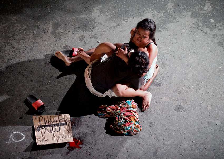 ATTENTION EDITORS - VISUAL COVERAGE OF SCENES OF INJURY OR DEATH Jennelyn Olaires, 26, cradles the body of her partner, who was killed on a street by a vigilante group, according to police, in a spate of drug related killings in Pasay city, Metro Manila, Philippines July 23, 2016. A sign on a cardboard found near the body reads, "Pusher Ako", which translates to "I am a drug pusher." REUTERS/Czar Dancel/File Photo TPX IMAGES OF THE DAY - RTX2MU4X